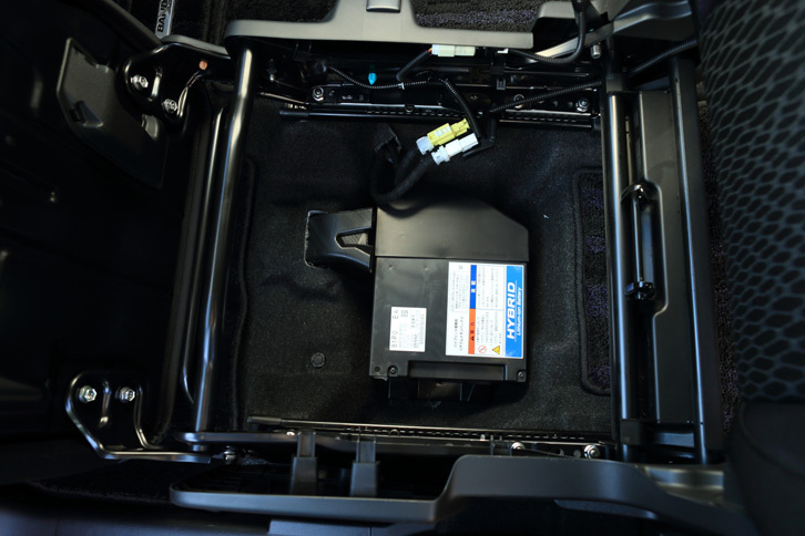 一般的な鉛バッテリーに、マイルドハイブリッド車と同じ12Vのリチウムイオンバッテリー（写真）、そして走行用に追加された100Vのリチウムイオンバッテリーと、「ソリオ」のフルハイブリッド車には3つもバッテリーが搭載されている。