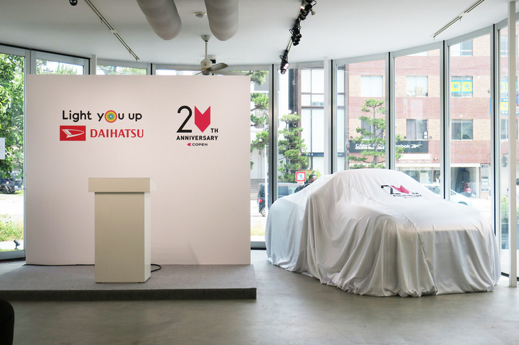 登壇者用のステージと、ベールに隠された「ダイハツ・コペン20周年記念特別仕様車」。