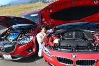 「BMW 320d」と「マツダCX-5 XD」のエンジンルームを比較中の筆者。（写真＝池之平昌信）