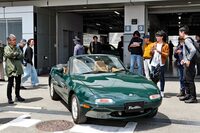 会場に展示されたグリーンの「ユーノス・ロードスター」と、4代目ロードスターの開発主査を務めた山本修弘さん（写真向かって左）。