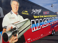 「俺ゃー、マリオだぁ」。孫マルコの急成長に目を細めて喜んでいるマリオ・アンドレッティ。アフター系パーツの広告に多数登場し、タレント業としては息子マイケルを凌ぐ人気がある。