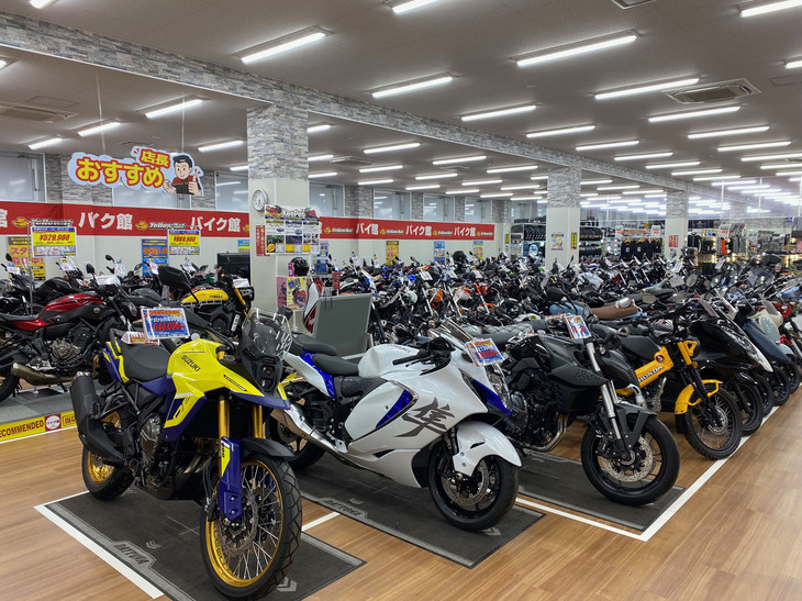 あらゆるブランドの中古バイクがずらりと並ぶ「バイク館」の店内。店舗運営部の新井雄介さんは、「長期にわたる円安と、それに伴う海外からの買い付け需要の増加こそが、国内の中古バイク価格が高騰している最大の要因」と語る。