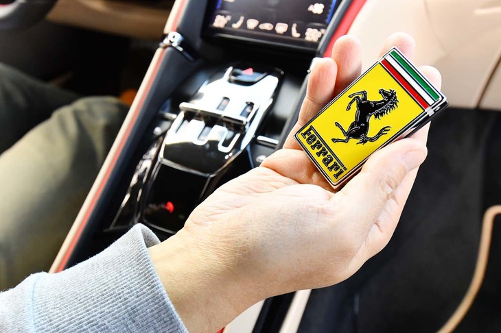 ボンネットエンブレムを思わせるデザインのキーフォブ。センターコンソールのシフトセレクター手前に、固定するためのスペースが設けられている。