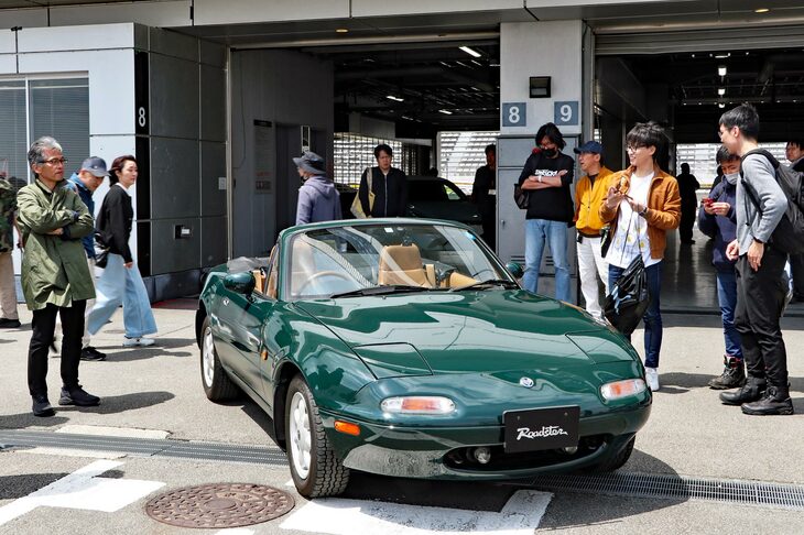 会場に展示されたグリーンの「ユーノス・ロードスター」と、4代目ロードスターの開発主査を務めた山本修弘さん（写真向かって左）。