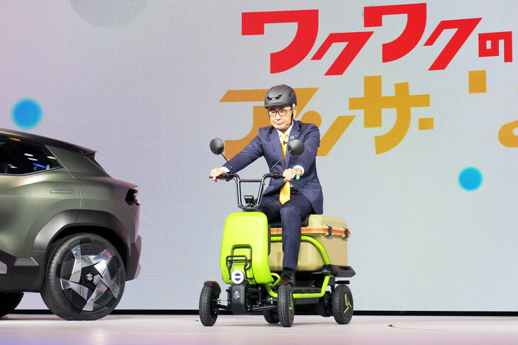 「スズライド」に乗ってステージに現れるスズキの鈴木俊宏社長。