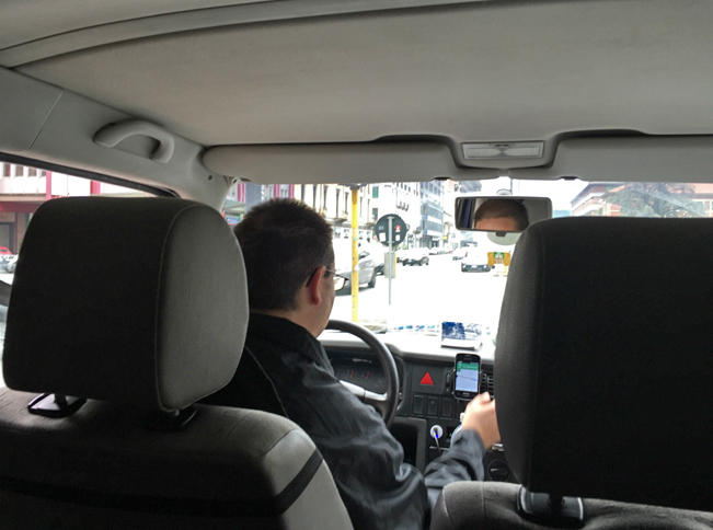 運転中のファブリツィオ氏。イタリアでウーバーのドライバーになるには、まず地方自治体が管轄するハイヤー業者として登録しなければならない。
