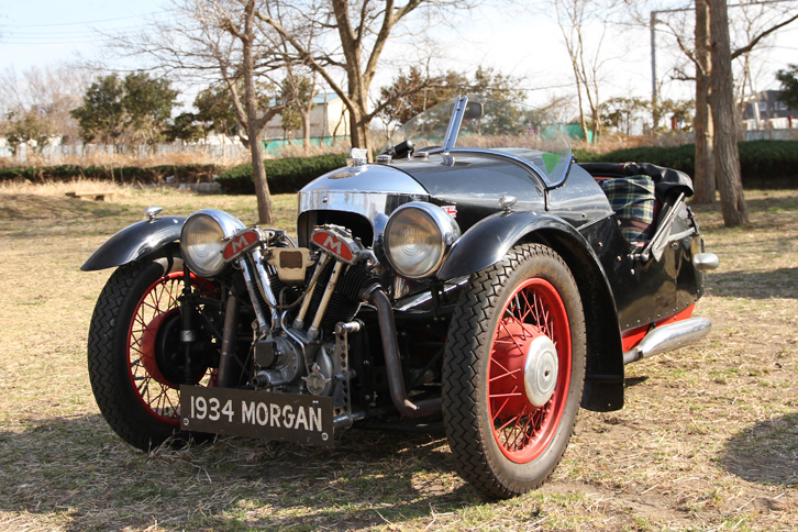 1934年「モーガン3ホイーラー」。数年前に復刻版が登場したモーガン3ホイーラーの、戦前に作られたモデル。ノーズにむき出しで積まれたマチレス製の二輪用空冷Vツインエンジンで、後ろの一輪を駆動する。