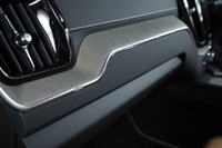 上級グレード「インスクリプション」に用いられる装飾パネルは、流木をモチーフにしたという風合いが特徴。助手席側のモールディングには、スウェーデン国旗を模したとおぼしき、小さな十字架がデザインされている。