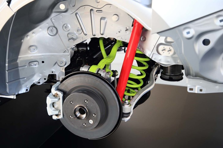 解説用ベアシャシーのリアサスペンション周辺部。写真でグリーンに見えるアッパーアームやコイルスプリングは従来モデルより軽量化、上質な乗り心地と高い旋回G領域における高いコントロール性が追求された。