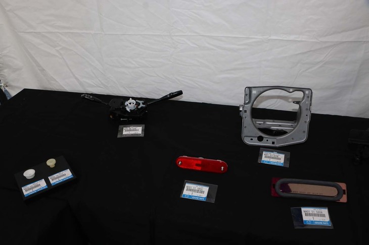 レストアチームのブースに展示された復刻部品（一部）。金属製のフレームは、リトラクタブルヘッドライトのもの。最新の復刻部品では、これまでブレーキキャリパーは、アッセンブリーパーツでしか入手できなかったが、オーバーホールに必要なピストンを単品で用意したという。これで安価なブレーキオーバーホールが可能となる。