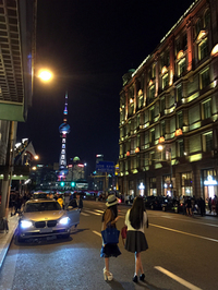 上海随一のホテル「和平飯店」前にて。ファッショナブルな小姐（お姉さん）の向こうで、最新スマートフォンを操る若者が上海ナンバーのBMWに乗り込んだ。