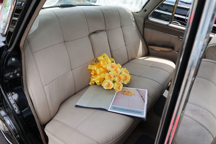 高級ながら上品な雰囲気の後席。座面に置かれたブーケはカタログに倣ったもの。ドア内張りなども専用デザインで、当時は珍しかったパワーウィンドウが標準装備されている。