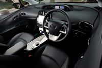 新型「プリウス」のインストゥルメントパネルまわり。先代モデルの特徴だった、ダッシュボードとアームレストをつなぐような意匠のセンターコンソールは廃止され、代わりに2つのドリンクホルダーを持つコンソールトレーが採用された。