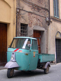 街角に止まる3輪トラック「アペ500」。フロントには赤い斜線が。