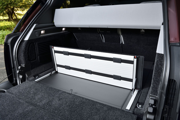 テールゲートは「レンジローバー」の伝統にのっとり上下2分割式が採用される。後席を使用した際の荷室容量は818リッター、後席を倒した状態では同1841リッターとなる。フロア床面には、格納式のグローサリーバックホルダー（写真）が組み込まれていた。