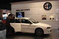 「アルファ147 2.0ツインスパークC'N'C'」。ブースにはコスチュームナショナルのアイテムが展示され、コレクションの映像も流される。 
    