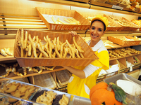 フェラーラのご当地パン「コッピア」の入ったバスケットを抱える店員のアリーチェさん。