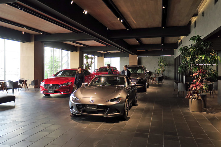 板橋本店の1階はエントランスのみで、階段／エレベーターを上がった2階がショールームとなっている。関東マツダの本社屋の建て替え、および板橋本店のリニューアルに関しては、マツダのデザイン本部が監修。特にショールームについては、モーターショーのブースを手がけるメンバーも携わり、クルマが美しく見えるよう採光までこだわった空間を実現したという。