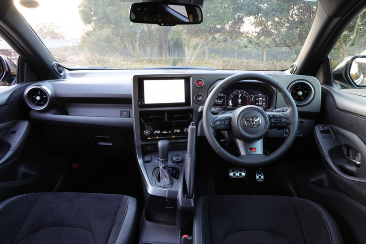 ダッシュボードは「GRヤリス」専用となるデザイン。ドライバーの操作性や視認性が第一に考えられた、機能優先の戦うためのコックピットである。「GRガンメタル塗装」が施され「GR」エンブレムが付く本革巻き3本スポークステアリングホイールは、グリップ形状やフィット感などにこだわって開発されたアイテムだ。