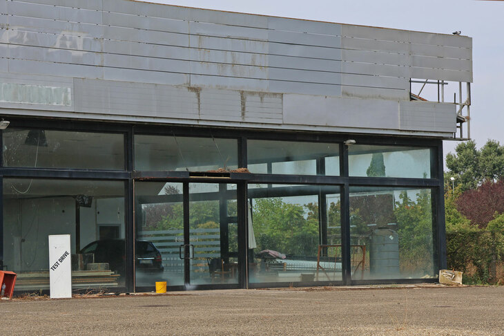 シエナ県で。かつて日産、GM大宇製のシボレーを売っていた販売店は、廃墟となって久しい。2023年8月撮影。