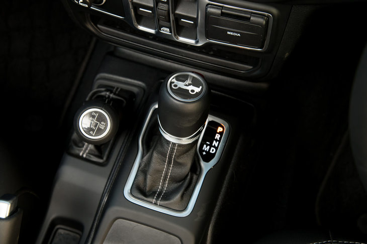 日本導入を記念した特別仕様車「アンリミテッド サハラ ローンチエディション」専用の本革巻きシフトノブと、4WD機構を操作するトランスファーレバー。走行モードには「2H」「4H AUTO」「4H」「4L」の4種類が用意される。