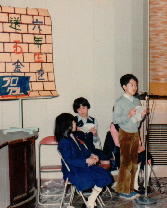 小学校5年生の筆者。左後方のプログラムも筆者の手書きである。