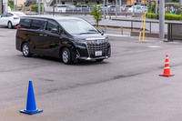 工場の敷地内に黄色と赤と青のパイロンをそれぞれ1本ずつ配置。日本語でパイロンの色を指定し走行を指示すると、自動運転システムを搭載した「アルファード」がゆっくりと指示された色のパイロンに向かって走る様子が確認できた。