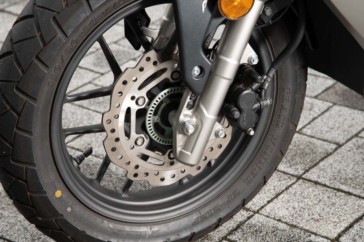 フロントフォークは正立タイプ。放熱性に優れる花弁型のブレーキディスクがおごられている。