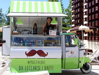 ミラノエキスポ会場で。チョコレートドリンクの屋台は、「ピアッジョ・アペ」を改造した、レスティ社の「オイスター」というモデルで、大きな可動式シェード＆ルーフをもつ。中では炎暑の中、お姉さんが奮闘していた。