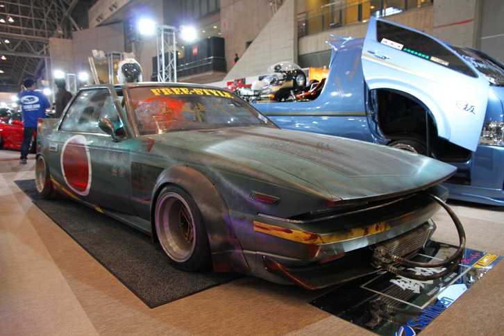 フリースタイルのブースに飾られていた、チーム鉄板の初代「トヨタ・ソアラ」（Z10）をベースにした名称不明のマシン。モチーフはご覧のとおり旧日本軍の戦闘機で、つや消しの汚し塗装仕上げによって妙にリアリティーの感じられる姿となっている。