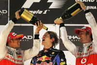 セバスチャン・ベッテル（中央）、最終戦を圧勝し逆転チャンピオンに。2位に入った2008年の王者、ルイス・ハミルトン（左）、3位でフィニッシュした2009年チャンプのジェンソン・バトン（右）に祝福された。（写真＝Red Bull Racing）