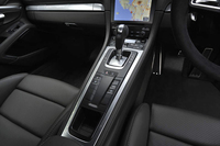 後方に向かってなだらかに傾斜したセンターコンソール。シフトレバーの手前には、サスペンションの設定ボタンやリアウイングの調節スイッチが並ぶ。