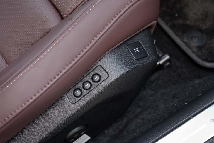マッサージ機能のスイッチはフレーム部分にレイアウトされる。サイドサポートの内側に見えるのが真珠のネックレスをモチーフにしたというパールトップステッチで、キャビンのところどころに使われている。