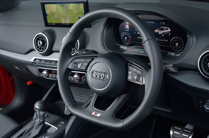 下部がフラットな形状の本革巻きステアリングホイール。インフォテインメントシステムの操作スイッチやシフトパドル、S lineエンブレムが備わる。