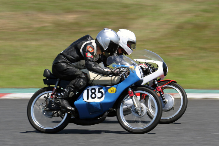 1960年代の小排気量のモーターサイクルによるビンテージツーリストトロフィーで2位に入った1964年「ブリヂストン90 EA1」（手前）と3位の1969年「ヤマハAS-1」（奥）のバトル。かつてブリヂストンは2ストロークエンジン搭載の二輪を製造しており、なかでもこの90は基本的にはプレスフレームのビジネスバイクながら、ロードレースやモトクロスでも大活躍した。