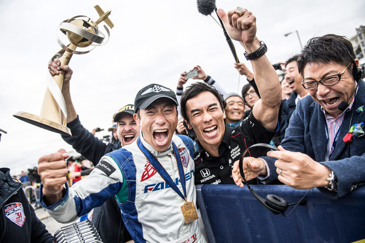 2017年のレッドブル・エアレースでシリーズチャンピオンに輝いた室屋義秀選手（中央左）と、室屋選手を祝福するレーシングドライバーの佐藤琢磨選手（中央右）。（Joerg Mitter/Red Bull Content Pool）