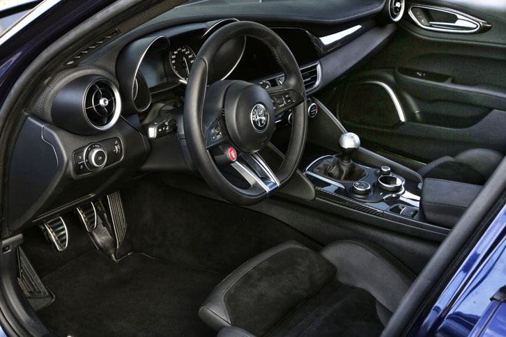 「クアドリフォリオ」のインテリアはご覧のとおりスパルタンな装い。ブラックレザー＆アルカンターラのトリムに、カーボンとアルミのアクセントが添えられている。