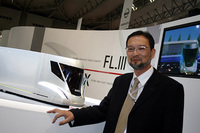 いすゞデザインの中尾博さん。後方はコンセプト「FL-III」ディーゼル＋インホイールモーターを想定。
