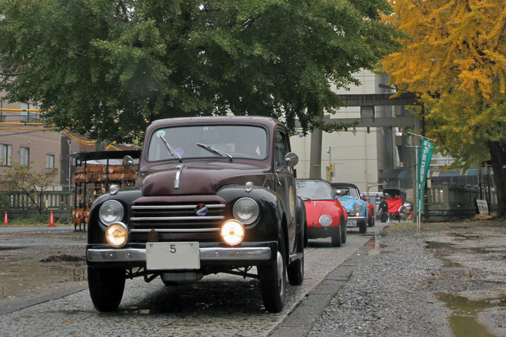 「5」で始まる陸運支局名がなかった時代の東京ナンバーを付けた1953年「フィアット500C」を先頭にスタンプ待ち。後方、鳥居のところに人力車が見える。
