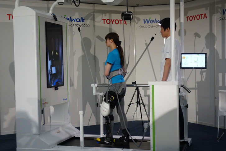まひした脚にロボット脚を装着して、トレッドミル上でリハビリを行う。
