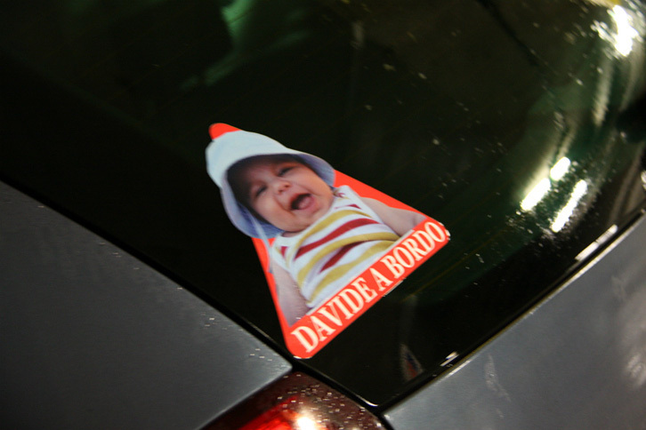 実際の子供の写真と、名前（この場合ダビデ君）をプリントした、子供乗せてますステッカー。2009年撮影。