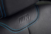 シートの背もたれの上部には、Mロゴがエンボス加工されている。