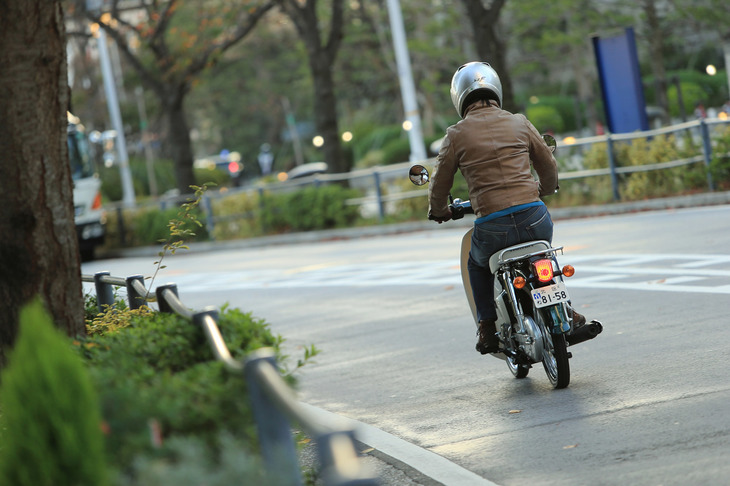 公道を走る「ホンダ・スーパーカブ50」。50ccの原付には、30km/hの法定最高速度や2段階右折の義務付けなど、さまざまな法的制約が課せられている。（写真＝荒川正幸）