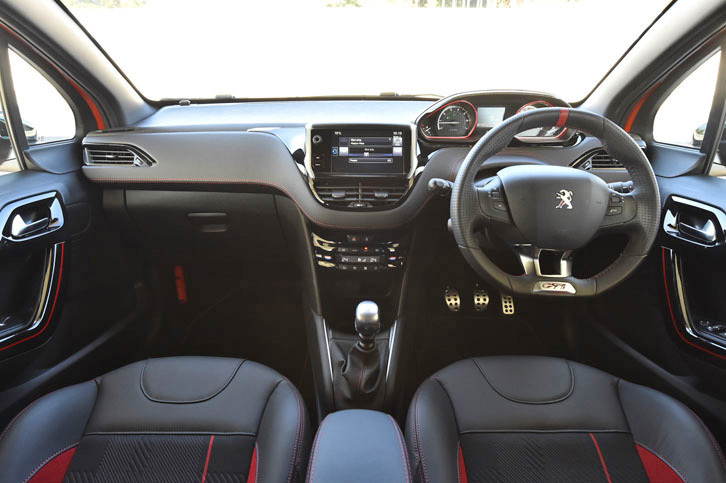 「プジョー208GTi」のインテリア。ステアリングホイールやシート、メーター、ドアパネルに赤いアクセントが添えられるほか、テップレザーのダッシュボードや革巻きのサイドブレーキカバーには赤いステッチが施される。