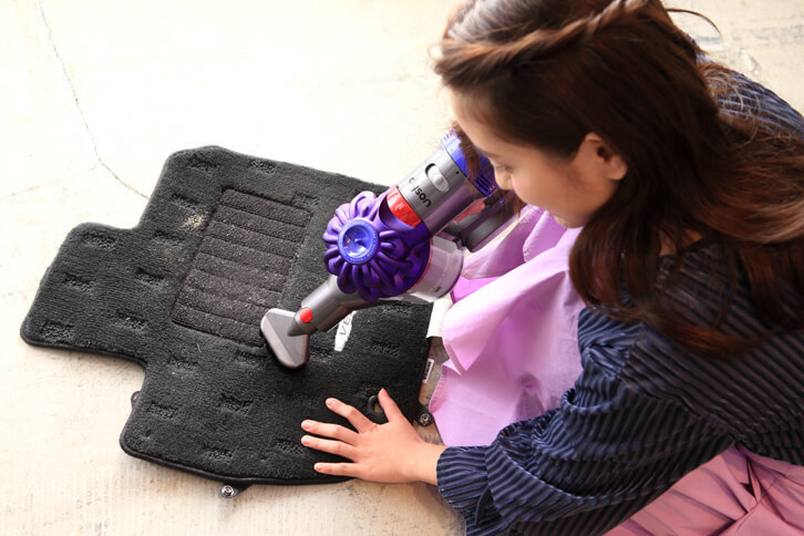 はたいただけでは落ちないゴミを取り除くため、フロアマットをハードブラシでゴシゴシ。