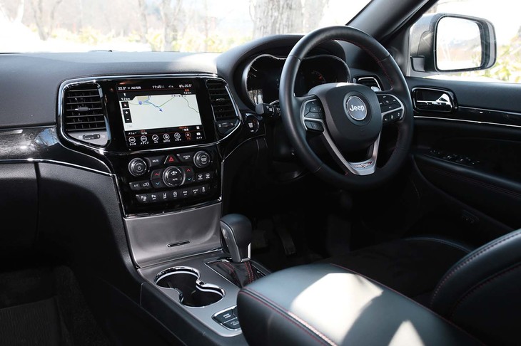 ブラック基調でコーディネートされた「グランドチェロキー トレイルホーク」のインテリア。ガンメタリックやピアノブラックのパネル類でドレスアップされている。
