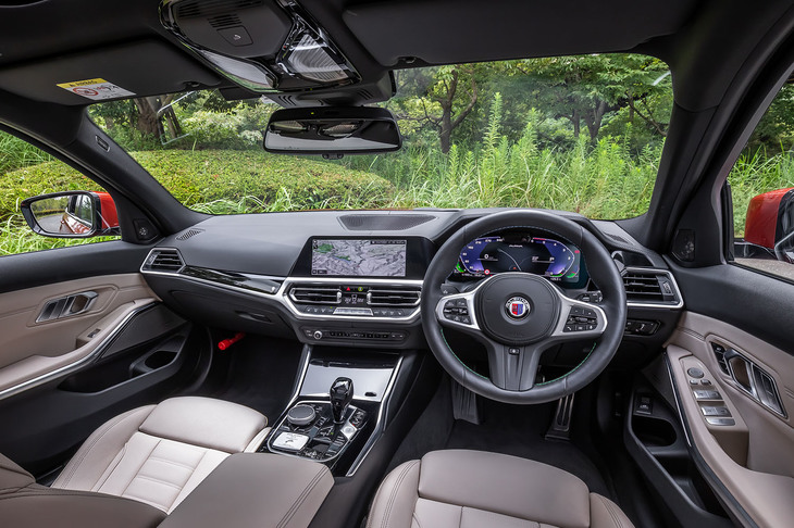 「スイッチトロニック」の操作ボタンやヒーター機能が組み込まれた「アルピナスポーツレザーステアリング」が目を引くコックピット。センターコンソールには、製造番号が記されたプロダクションプレートが備わる。