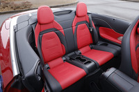 2人掛けの後席はソフトトップを開けてしまえばヘッドルームは無限大（当たり前）。シート自体は小ぶりだが、きちんとアームレストやカップホルダーが備わっている。