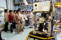 
	工場見学の1コマ。写真は、組上がったエンジンのテストユニット。ロータリーは静粛性が高く、ワインをいれたグラスを回転するエンジンに乗せるパフォーマンスでも、ワインにさざ波がたつのみ。（写真＝マツダ）
	 