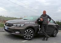 地元ディーラーでセールスマン歴18年のアンドレアと「フィアット・ティーポ」。本日はプラダのベストで営業活動。